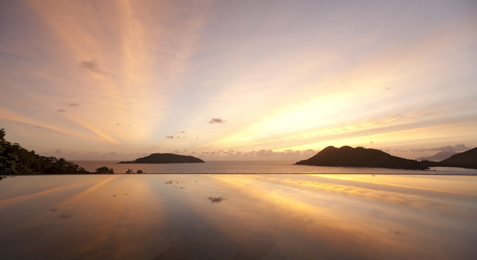 Piscine à débordement au ras de l'eau au coucher du soleil