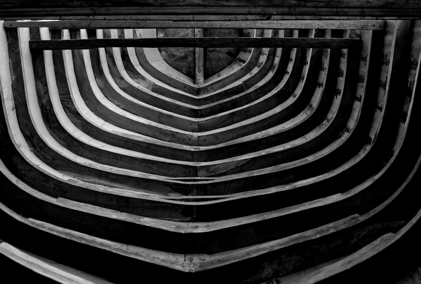 Membrures d'une coque de bateau en bois formant des courbes graphiques, photographie en noir et blanc