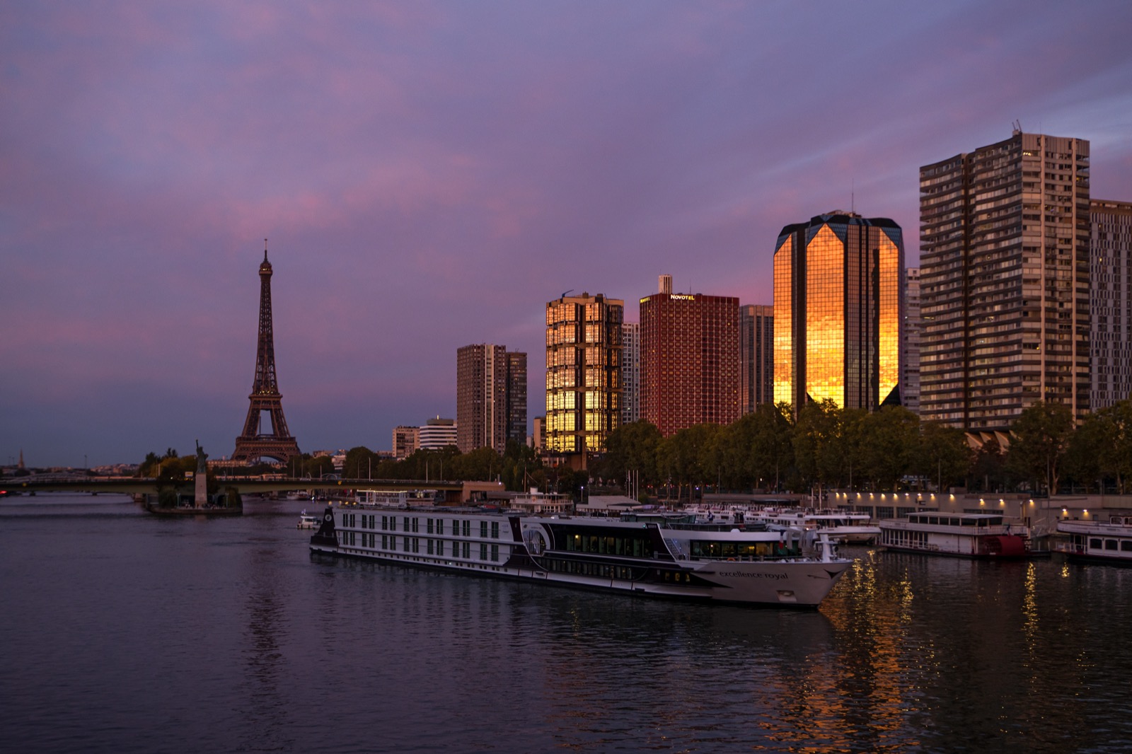 La tour Eiffel et un bateau de croisière sur la Seine au crépuscule